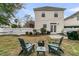 A backyard with a firepit, wooden chairs, string lights, and a white fence at 2369 Chadbury Ln, Mount Pleasant, SC 29466