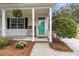 Inviting front porch featuring hanging plants, a cozy bench, and a freshly painted green door at 2369 Chadbury Ln, Mount Pleasant, SC 29466