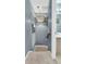 Transitional hallway featuring carpeted stairs, a charming chandelier, blue walls, and a partial view of a bathroom at 2369 Chadbury Ln, Mount Pleasant, SC 29466