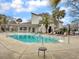 Relaxing community pool area with lounge chairs, palm trees, and clubhouse in a beautiful and well-maintained setting at 268 Alexandra Dr # 9, Mount Pleasant, SC 29464