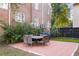 A spacious backyard patio with brick pavers, a dining set, and mature landscaping creating an outdoor living area at 301 Broad St # 1, Charleston, SC 29401
