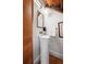 Contemporary powder room features a pedestal sink, gold-framed mirror, and stylish lighting fixtures at 301 Broad St # 1, Charleston, SC 29401