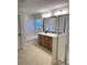 A bathroom features a large vanity mirror, white bathtub, and tiled floor at 3059 Adventure Way, Ladson, SC 29456