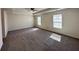 Spacious bedroom featuring neutral walls, plush gray carpeting, two bright windows, and a ceiling fan at 3059 Adventure Way, Ladson, SC 29456