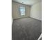 An airy bedroom features neutral walls, plush gray carpeting, and a bright window for natural light at 3059 Adventure Way, Ladson, SC 29456
