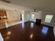 A spacious living room with gleaming hardwood floors, fireplace, and ample natural light from two windows at 3059 Adventure Way, Ladson, SC 29456