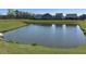 Scenic community pond reflecting nearby homes, complemented by lush green surroundings at 3059 Adventure Way, Ladson, SC 29456