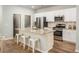 Modern kitchen boasts stainless steel appliances, a granite island, and white cabinetry at 313 Pine Crest View Dr, Summerville, SC 29486