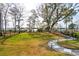 Spacious backyard with lush lawn and waterfront views, complete with lighted walkway, enhancing the outdoor living experience at 384 Blowing Fresh Dr, Charleston, SC 29492