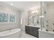 Bright bathroom with a standalone tub, double vanity, marble floors, and glass enclosed shower at 384 Blowing Fresh Dr, Charleston, SC 29492