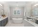 Bright bathroom with a standalone tub, double vanity, marble floors, and glass enclosed shower at 384 Blowing Fresh Dr, Charleston, SC 29492