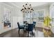 Bright dining area featuring a glass table, blue upholstered chairs, and wainscoting at 384 Blowing Fresh Dr, Charleston, SC 29492