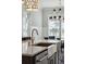 Close up of the kitchen island featuring a farmhouse sink, bronze faucet, and pendant lighting at 384 Blowing Fresh Dr, Charleston, SC 29492