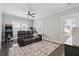 Living room featuring a ceiling fan, large rug, dark wood floors, and comfortable leather couch at 384 Blowing Fresh Dr, Charleston, SC 29492
