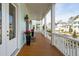 Inviting porch with wood flooring, white columns, and decorative planters, offering a charming outdoor space at 384 Blowing Fresh Dr, Charleston, SC 29492