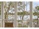 Scenic view from the screened porch featuring a beautiful lake, dock, and lush trees at 384 Blowing Fresh Dr, Charleston, SC 29492