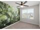 Bright bedroom with a nature-themed accent wall, ceiling fan, and a window providing natural light at 407 Stoneleigh Ln, Moncks Corner, SC 29461