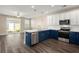 Bright kitchen with stainless steel appliances, marble countertops, blue lower cabinets, and sliding glass doors at 407 Stoneleigh Ln, Moncks Corner, SC 29461