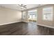 Light-filled living room with large sliding doors and windows, laminate floors, and neutral walls at 407 Stoneleigh Ln, Moncks Corner, SC 29461