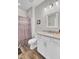 Bright bathroom featuring a shower with patterned curtain and a white vanity with granite countertop at 409 Klein St, Walterboro, SC 29488