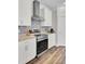Close-up of the stainless steel range and vent hood, complemented by light cabinets and granite countertops at 409 Klein St, Walterboro, SC 29488