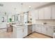 Open concept kitchen showcasing white cabinetry, quartz countertops, and seamless connection to the dining and living areas at 421 Grove End Rd, Moncks Corner, SC 29461