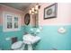 Vintage bathroom with tiled walls, pedestal sink, and decorative seashells and wall art at 562 Fort Johnson Rd, Charleston, SC 29412