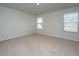 Bright bedroom featuring neutral carpet and two windows with blinds overlooking a pond at 607 Silver Spruce St, Summerville, SC 29486