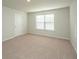 Neutral bedroom featuring neutral carpet, one window with blinds, and a white door at 607 Silver Spruce St, Summerville, SC 29486