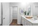 Bright bathroom featuring a double sink, a large mirror, and a doorway to a storage area at 6226 Gritman Dr, Hollywood, SC 29470