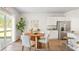 Bright kitchen nook featuring a wooden table, white chairs, and stainless steel refrigerator at 6230 Gritman Dr, Hollywood, SC 29470