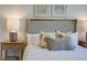 Close-up of a bedroom with a plush headboard, decorative pillows, and elegant bedside lamps at 6230 Gritman Dr, Hollywood, SC 29470