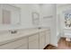 Bright bathroom with double sinks, wooden floors, and classic white fixtures and decorative mirrors at 741 Creekside Dr, Mount Pleasant, SC 29464
