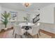 Dining area with wainscoting, wood floors, and a round table, illuminated by a vibrant light fixture at 741 Creekside Dr, Mount Pleasant, SC 29464