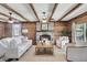 Inviting living room with a brick fireplace, wood paneling, exposed beams, and comfortable seating, perfect for gatherings at 741 Creekside Dr, Mount Pleasant, SC 29464