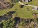 An aerial view showcasing a spacious property with a pond and multiple outbuildings at 760 Community Ave, Smoaks, SC 29481
