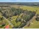 Aerial shot of a homestead with a pond surrounded by dense trees and green pastures at 760 Community Ave, Smoaks, SC 29481