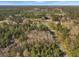 Elevated aerial view showcasing property access via paved road and surrounding wooded area at 760 Community Ave, Smoaks, SC 29481