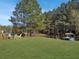 Outdoor seating area with colorful chairs next to a calm pond and lush trees at 760 Community Ave, Smoaks, SC 29481