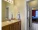 Bathroom featuring a wooden vanity, mirror, and doorway leading to bedroom at 760 Community Ave, Smoaks, SC 29481
