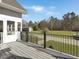 Back deck with iron railing overlooks the expansive yard and outbuildings at 760 Community Ave, Smoaks, SC 29481