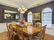Elegant dining room with a large wood table, eight chairs, a decorative chandelier and natural light through arched windows at 760 Community Ave, Smoaks, SC 29481