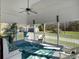 Screened porch with white furniture, tropical rug, fan and views of the backyard at 760 Community Ave, Smoaks, SC 29481