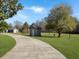 Long driveway leads to a well-maintained home, shed, and a tree with a swing in the yard at 760 Community Ave, Smoaks, SC 29481