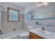 Bathroom with tiled walls, combination tub and shower, and single sink vanity at 7659 Allwood Ave, North Charleston, SC 29418