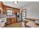 Traditional kitchen featuring wood cabinets, stainless steel refrigerator, and tile flooring at 7659 Allwood Ave, North Charleston, SC 29418