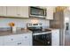 Modern kitchen with stainless steel appliances, white cabinets, and dark countertops at 8018 Rackham Rd, Hollywood, SC 29470