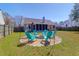 Spacious backyard with a cozy fire pit area surrounded by Adirondack chairs at 8506 Kennestone Ln, North Charleston, SC 29420