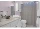 Well-lit bathroom featuring a vanity, ample cabinet space, and shower with patterned curtain at 8506 Kennestone Ln, North Charleston, SC 29420