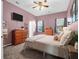 Serene bedroom with muted mauve walls, carpet, and a comfortable bed with soft lighting and a dresser at 8506 Kennestone Ln, North Charleston, SC 29420
